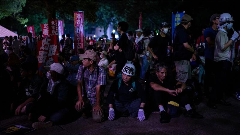 Demonstranten sitzen vor der Atombombenkuppel vor dem Gedenkgottesdienst zum 80. Jahrestag des US-Atombombenabwurfs auf Hiroshima im Zweiten Weltkrieg.