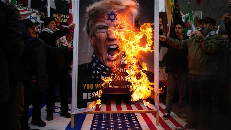Demonstranten verbrennen ein Poster von US-Präsident Trump während einer Kundgebung gegen die USA und Israel zur Unterstützung der iranischen Regierung vor dem US-Konsulat in Istanbul.