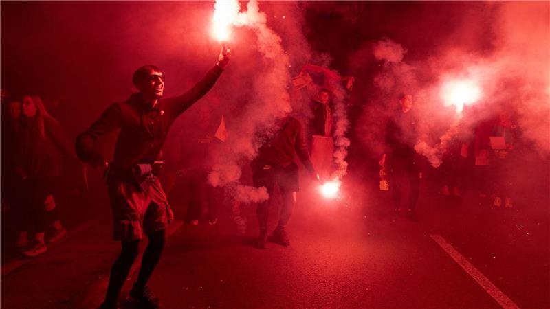 Demonstranten zünden Fackeln bei einer Kundgebung zum ersten Jahrestag der Bahnhofskatastrophe in Novi Sad an.