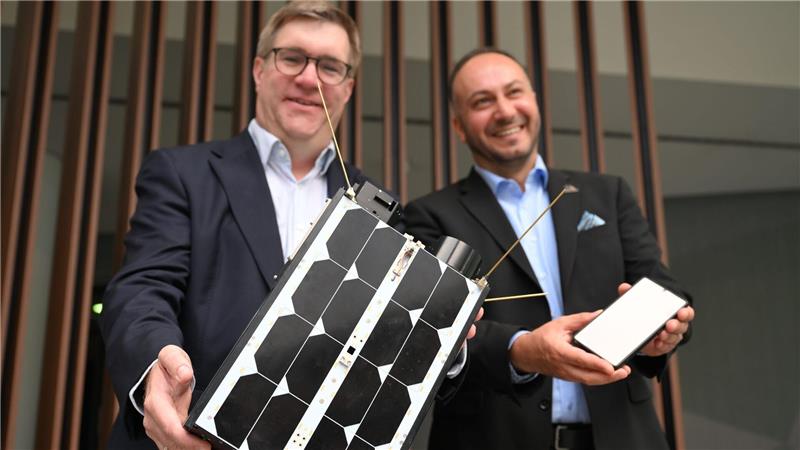Demonstrativ gute Laune von O2-Manager Jörg Kablitz und OQ-Chef Omar Qaise, die bei der Vorstellung ihres Vorhabens ein Modell eines Satelliten dabeihatten. 