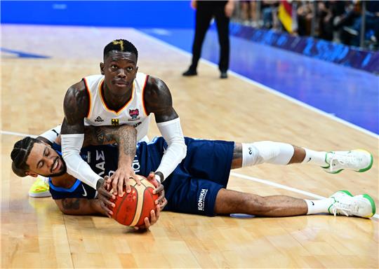 Dennis Schröder (Deutschland) nimmt dem am Boden liegenden Tyler Dorsay (Griechenland) den Ball weg. Foto: Stache/DPA