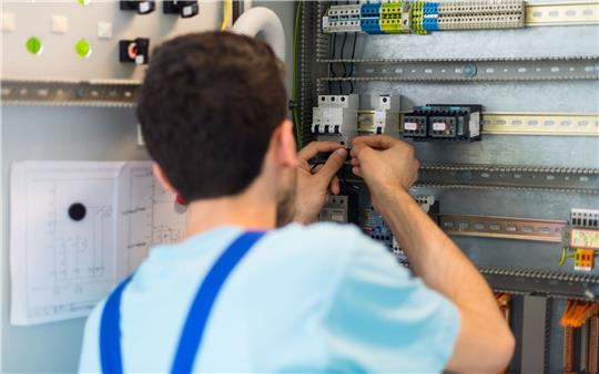 Der 19-jährige Mohammad aus Afghanistan arbeitet im Ausbildungszentrum der Siemens Professional Education an der Verdrahtung eines Schaltschranks.