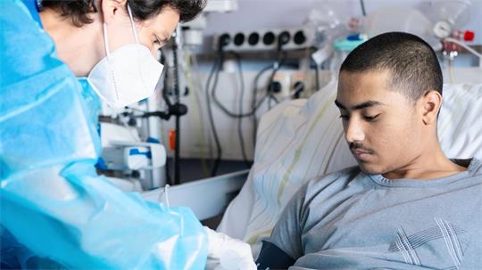 Der 19-jährige Mohammad liegt in einem Krankenhausbett an der Berliner Charité.
