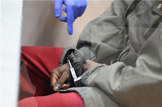 Der 32-jährige Angeklagte sitzt mit Handschellen im Gerichtssaal auf der Anklagebank. Er soll im Juni 2022 in einer Asylbewerberunterkunft am Bodensee auf mehrere Menschen eingestochen und dabei einen Mann getötet haben.