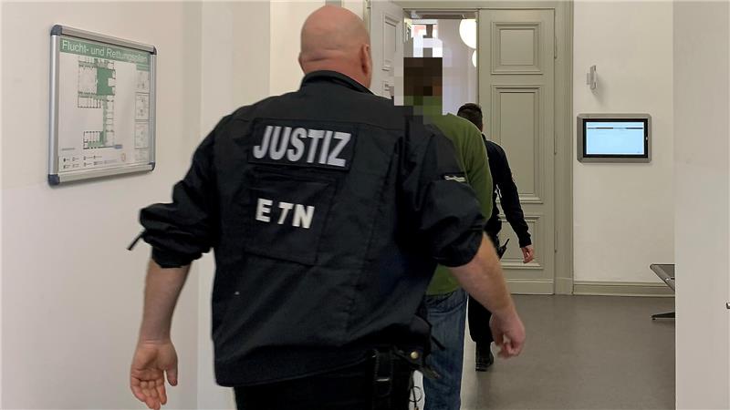 Der 47-jährige Tatverdächtige steht bereits mehrfach vor Gericht, er wird von Justizbeamten in den Gerichtssaal begleitet.