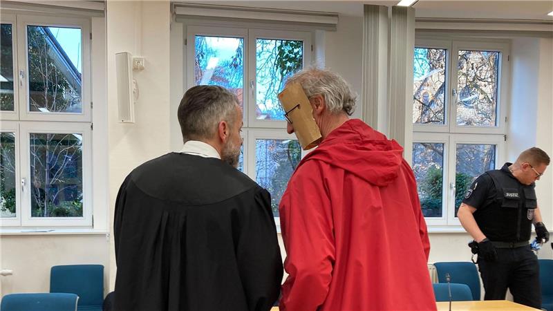 Der 53-jährige Angeklagte trug beim Betreten des Gerichtssaals eine augenscheinlich selbst gebastelte Papp-Maske, die sein Gesicht verdeckte.