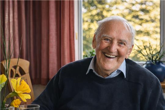 Ein Mann lacht in die Kamera.