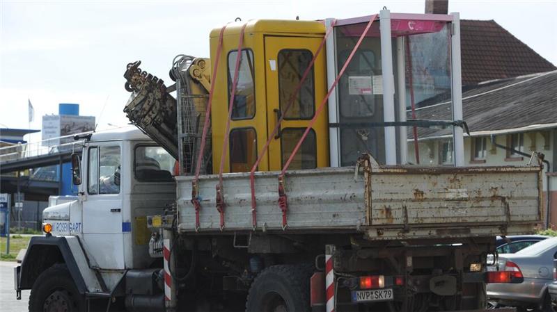 Elektroschrott am Wegesrand: Telefonzellen-Abbau dauert noch Der Abbau läuft schon seit langem: Hier werden in Sassnitz (Mecklenburg-Vorpommern) im Jahr 2010 zwei Telefonhäuschen zur Entsorgung abtransportiert. (Archivbild)