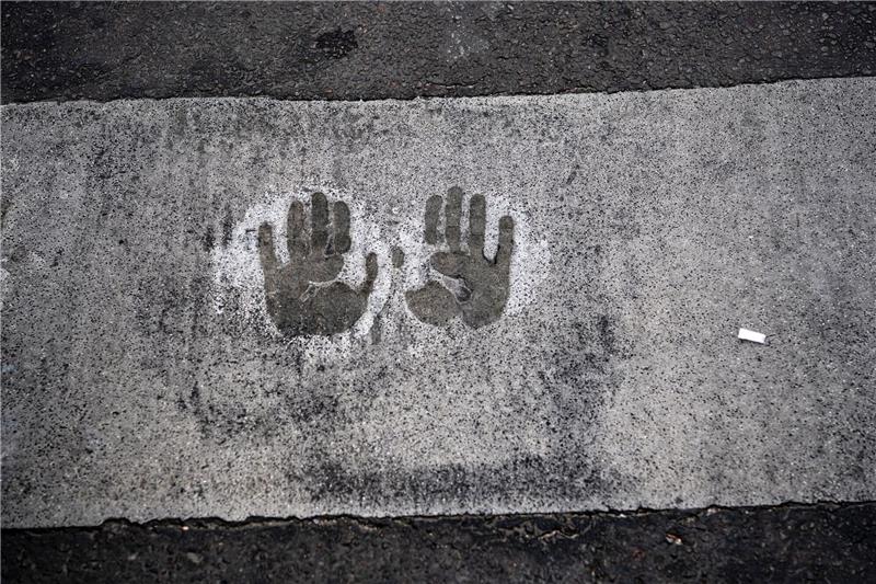 Die Letzte Generation und der Staat: Droht eine Eskalation? Der Abdruck von zwei Händen bei einer Straßenblockade der Letzten Generation auf dem Mühlendamm in Berlin.