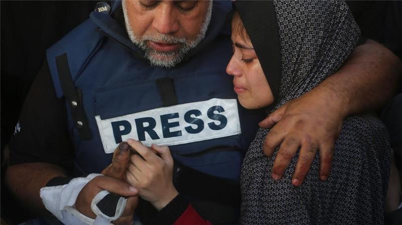 Der Al-Dschasira-Journalist Wael al-Dahdu hält die Hand seines Sohns Hamza, der ebenfalls für Al-Dschasira arbeitete und bei einem israelischen Luftangriff im Gazastreifen getötet wurde.