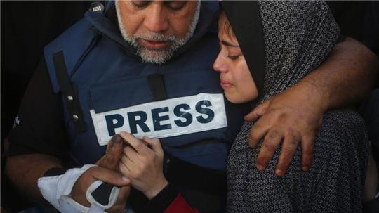 Der Al-Dschasira-Journalist Wael al-Dahdu hält die Hand seines Sohns Hamza, der ebenfalls für Al-Dschasira arbeitete und bei einem israelischen Luftangriff im Gazastreifen getötet wurde.