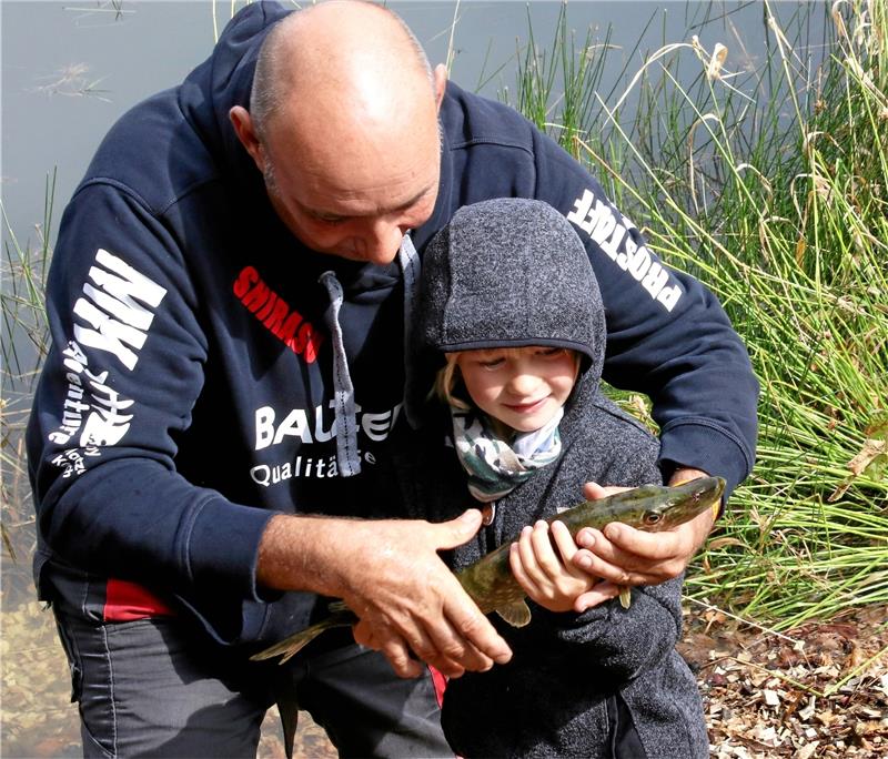 350 Besucher beim ersten Angelfest in Buntenbock Der Allround-Angler Dirk Ditters zeigt am lebenden Objekt, wie ein Fisch vorsichtig und nur mit nassen Händen angefasst wird. Der Hecht wird anschließend wieder in den Teich gelassen.