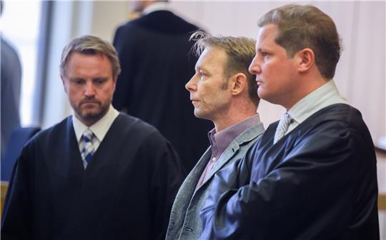 Der Angeklagte Christian B. (M) steht zu Prozessbeginn im Gerichtssaal im Landgericht Braunschweig neben seinen Anwälten Dennis Bock (l) und Friedrich Fülscher (r). Foto: picture alliance/dpa/dpa Pool | Julian Stratenschulte
