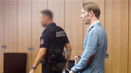 Der Angeklagte Christian B. (r) kommt mit Handschellen in den Gerichtssaal im Landgericht Braunschweig.