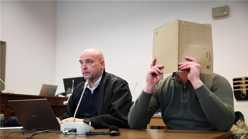 Der Angeklagte, der sein Gesicht verbirgt, soll Beihilfe zum Handel mit knapp 1,8 Tonnen Kokain geleistet haben. 