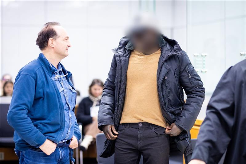 Ex-Soldat aus Gambia erhält in Celle lebenslange Haftstrafe Der Angeklagte (r) steht im Gerichtssaal.