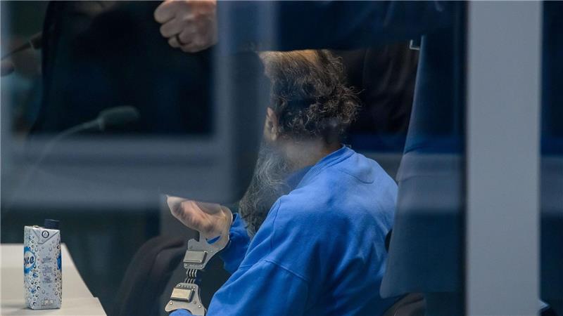 Der Angeklagte sitzt in einer Glaskabine im Verhandlungssaal. 