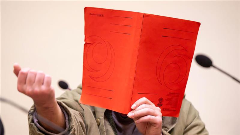 Der Angeklagte verdeckte sein Gesicht zum Prozessauftakt zunächst mit einer Mappe.