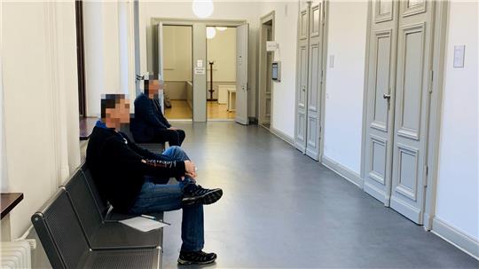 Der Angeklagte (vorn) erscheint freiwillig zu jedem Verhandlungstag und wartet auf dem Gerichtsflur.