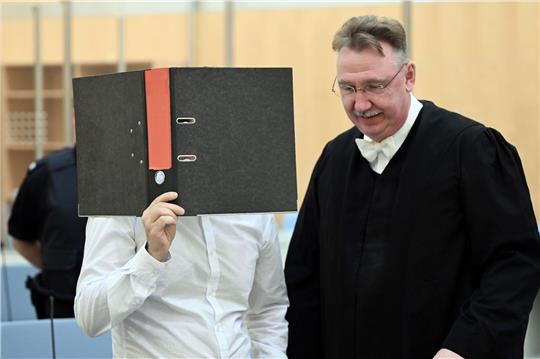 Der Angeklagte wartet mit seinem Anwalt im Gerichtssaal des Oberlandesgerichtes.