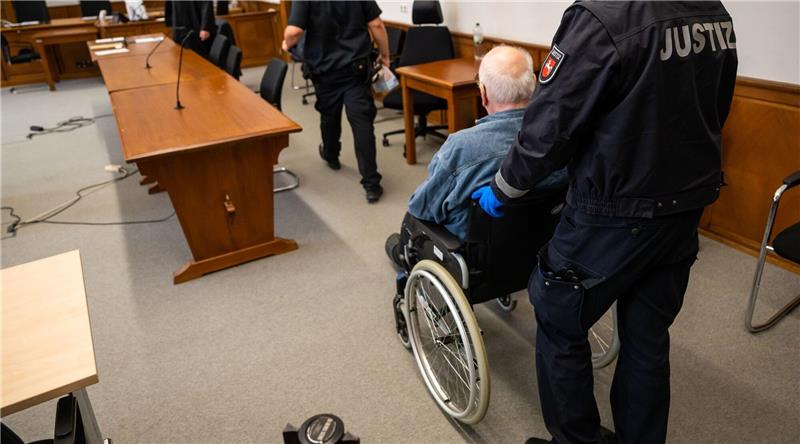 Lebenslang für 79-Jährigen wegen Mordes an Ehefrau Der Angeklagte wird im Rollstuhl in den Saal des Landgerichts geschoben.