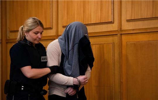 Der Angeklagte wird zu Beginn eines Prozesses wegen Mordes von einer Justizbeamtin in einen Gerichtssaal des Landgerichts Heilbronn  geführt.