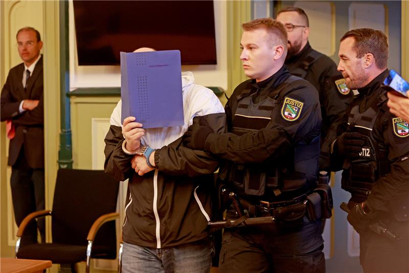 Der Angeklagte wird zu Prozessbeginn in den Gerichtssaal gebracht. Foto: picture alliance/dpa | Matthias Bein