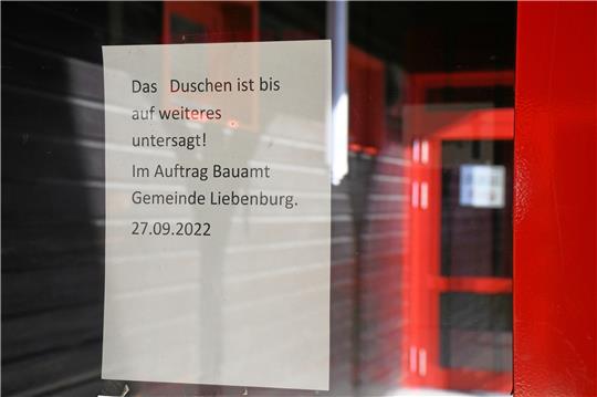 Der Arkadengang der Grundschule Othfresen spiegelt sich in der Eingangstür der Turnhalle, an der das Schild mit dem Dusch-Verbot haftet.  Foto: Gereke