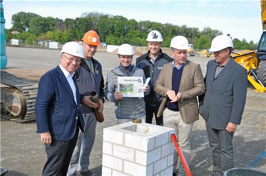 Der Bosch-Service Meyer stellt sich neu auf (v. l.): Seniorchef Dr. Wolf-Michael Schmid, Polier Reinhold Kahmann, Axel Pätzold und Timo Friehe als Goslar-Vienenburger Partner am Bau, Juniorchef Jan-Michael Schmid und der Goslarer Betriebsleiter Thomas Schumann legen eine aktuelle GZ in die Hülse und setzen anschließend den Grundstein. Foto: Heine