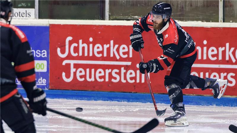Ein Eishockeyspieler schießt den Puck.