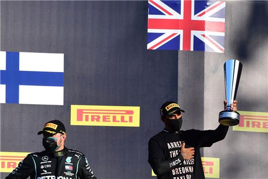 Der Brite Lewis Hamilton (r) zeigt bei einer Siegerehrung politische Botschaften auf seinem T-Shirt.