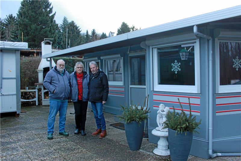 Der Camper hat seinen Platz unter einem Carport gefunden (rechts). Für Urlaubsfahrten wird er von den Rühmanns aber weiter benutzt. Oben von links: Axel Rühmann, Christine Rühmann und Jürgen Wilkens vor dem Zelt der Rühmanns.  Fotos: Fricke