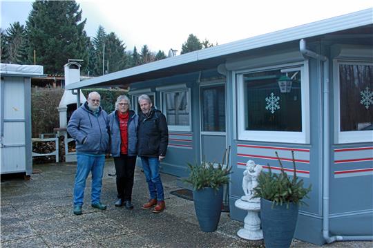 Der Camper hat seinen Platz unter einem Carport gefunden (rechts). Für Urlaubsfahrten wird er von den Rühmanns aber weiter benutzt. Oben von links: Axel Rühmann, Christine Rühmann und Jürgen Wilkens vor dem Zelt der Rühmanns.  Fotos: Fricke