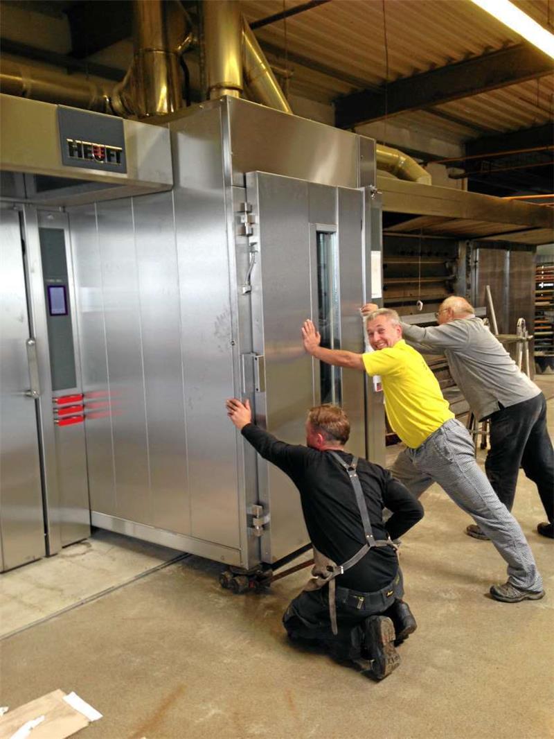 Der Chef schiebt an: Jürgen Braun (Mitte) platziert mit zwei Helfern einen neuen Ofen in der Astfelder Backstube.