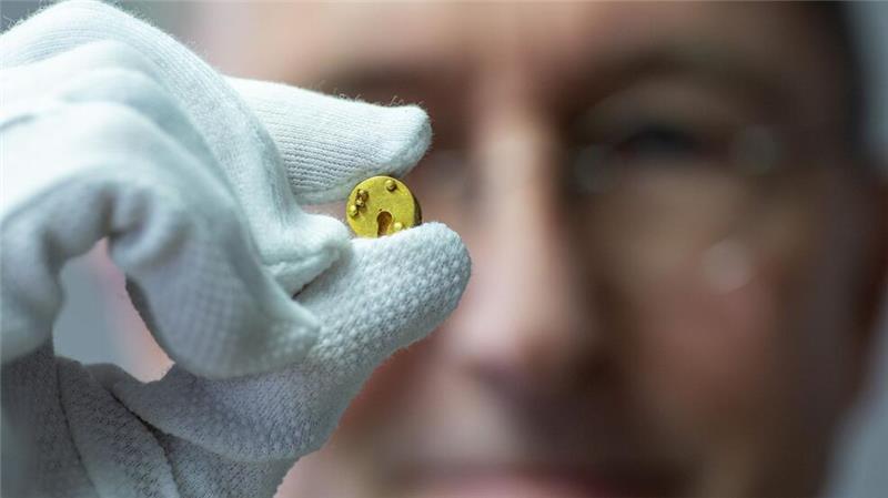 Römisches Mini-Dosenschloss aus Gold gibt Rätsel auf Der Chefarchäologe des LWL, Michael Rind, hält das Minischloss zwischen Daumen und Zeigefinger.