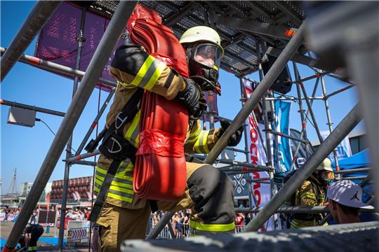 Der Feuerwehrmann Philipp Reumann von der Freiwilligen Feuerwehr Eckwarden steigt bei der «Firefighter Combat Challenge» in Bremerhaven mit einem Schlauch auf einen Turm.