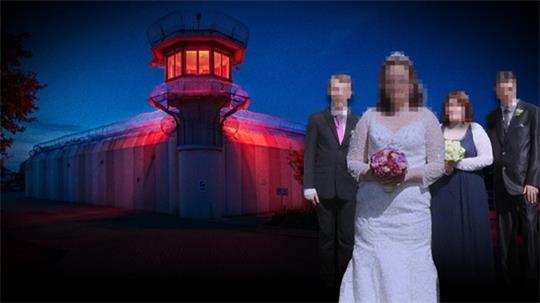 Brautpaar und zwei Trauzeugen vor einem beleuchteten Gefängnisturm in der Dämmerung.