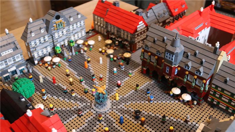 Modell eines historischen Marktplatzes mit Fachwerkhäusern, Brunnen und vielen kleinen Figuren aus Bausteinen.