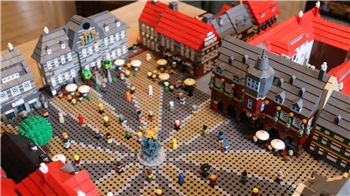 Modell eines historischen Marktplatzes mit Fachwerkhäusern, Brunnen und vielen kleinen Figuren aus Bausteinen.