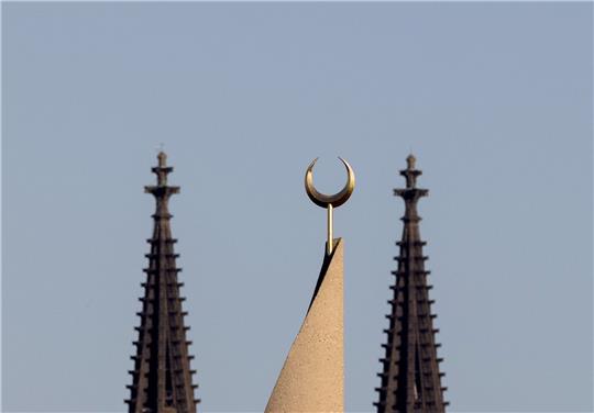 Der Halbmond auf einer Moschee ist zwischen den Türmen des Kölner Doms zu sehen. Der Auftritt eines hochrangigen afghanischen Taliban-Funktionärs in einer Kölner Moschee löst harsche Kritik aus.