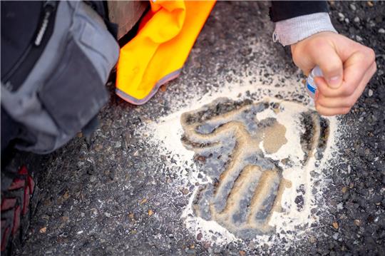 Der Handabdruck eines Aktivisten klebt auf der Straße.