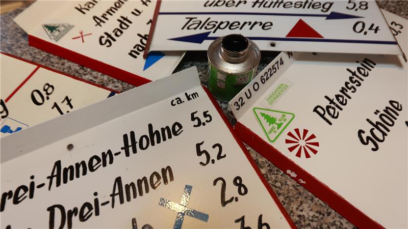 Wanderschilder liegen auf einem Tisch.