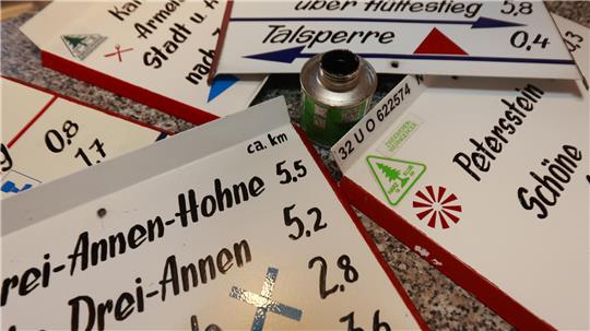 Wanderschilder liegen auf einem Tisch.