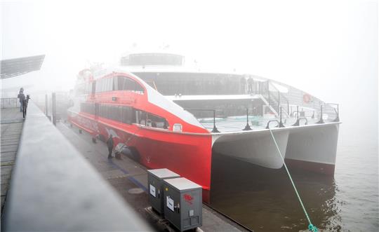 Der Helgoland-Katamaran «Halunder Jet» legt am Morgen im dichten Nebel im Hafen auf der Elbe.