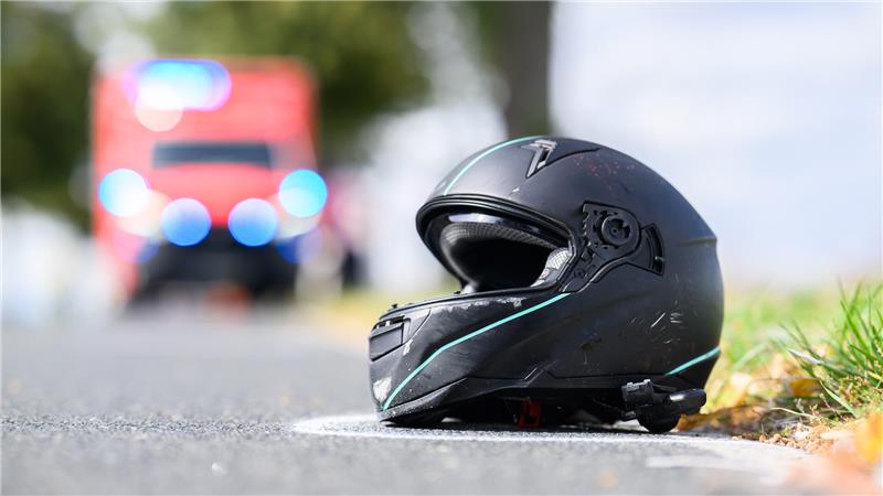Der Helm eines Motorradfahrers liegt nach einem Unfall auf der Straße