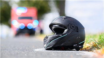 Der Helm eines Motorradfahrers liegt nach einem Unfall auf der Straße