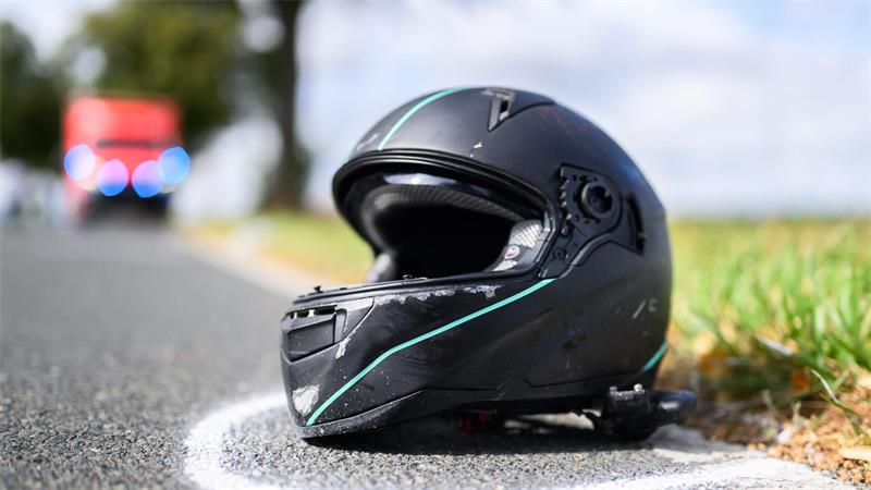 Der Helm eines Motorradfahrers liegt nach einem Unfall auf der Straße. (Symbolbild)