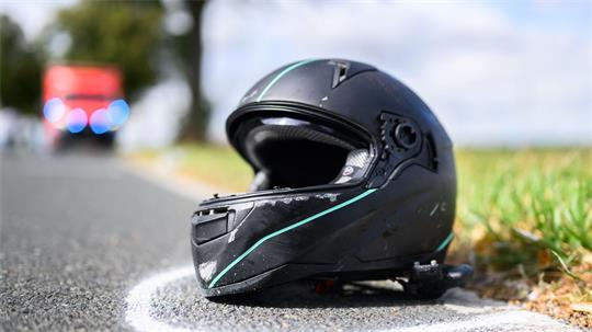 Der Helm eines Motorradfahrers liegt nach einem Unfall auf der Straße. (Symbolbild)