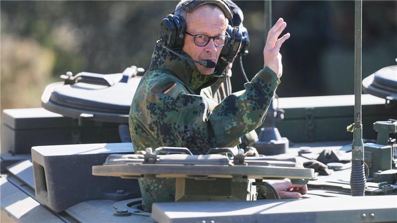 Der Kanzler grüßt aus einem gepanzerten Fahrzeug beim Truppenbesuch in Munster.