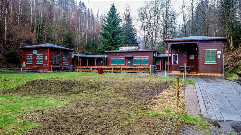 Der Kiosk am Altenauer Okerteich, im Vordergrund sind Wildschweinschäden und ein Elektrozaun zu sehen.